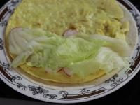 Omeletu vyklopíme na tortilu. Polovinu omelety...